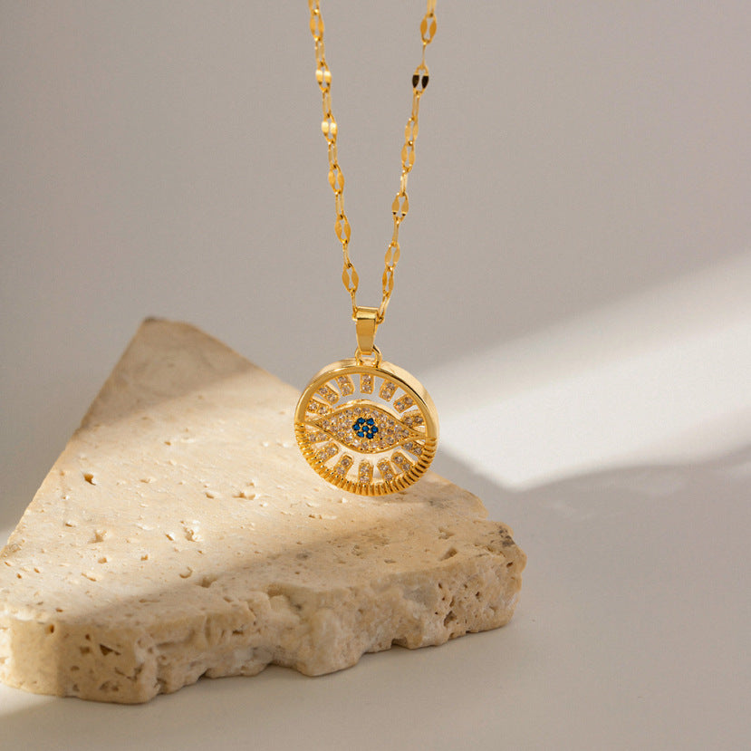 amethyst & sable calypso azure eye necklace in 18k gold above stone surface