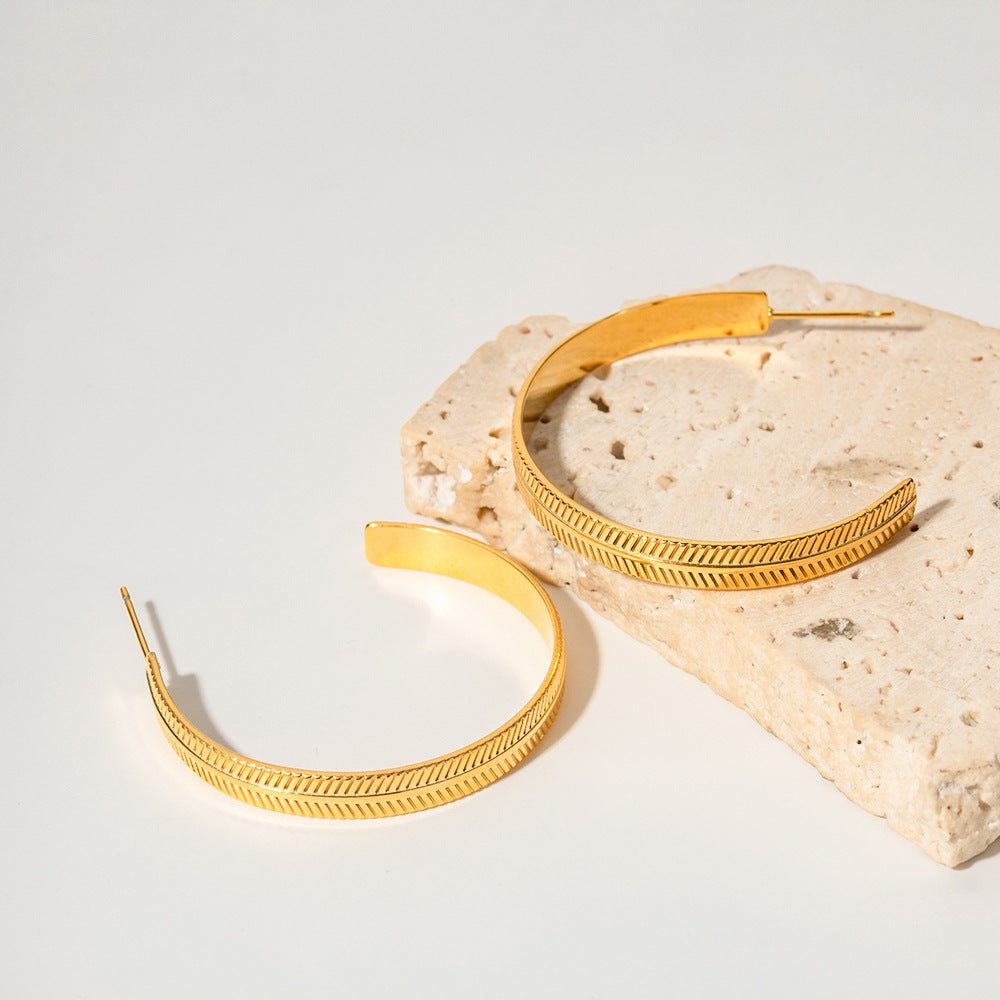 amethyst & sable calypso palm hoop earrings in 18k gold on stone surface