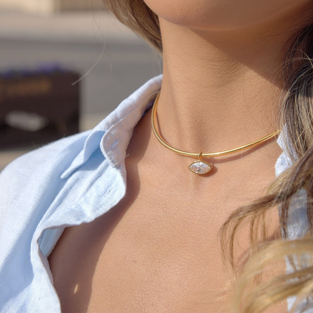 Gold aurea sol choker necklace with a marquise cubic zirconia pendant on a person's neck