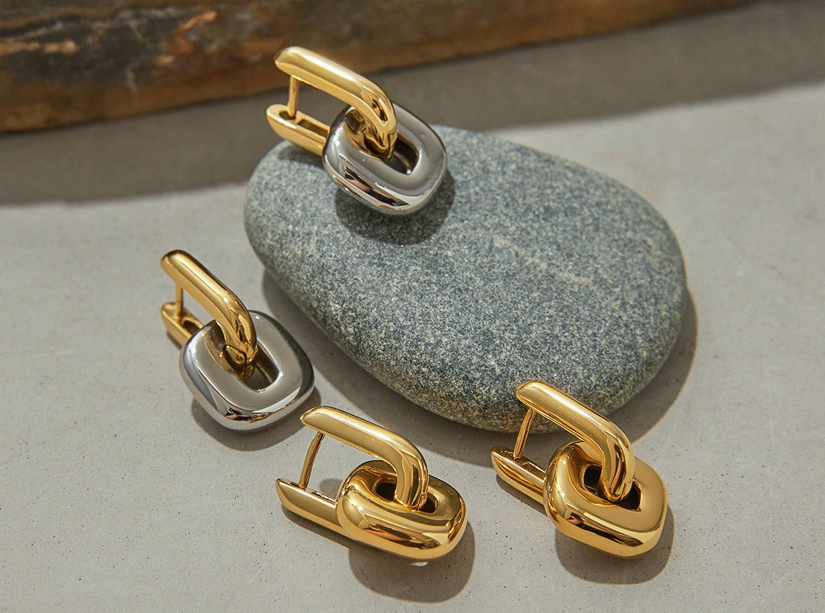 Gold and silver earring set on a stone surface