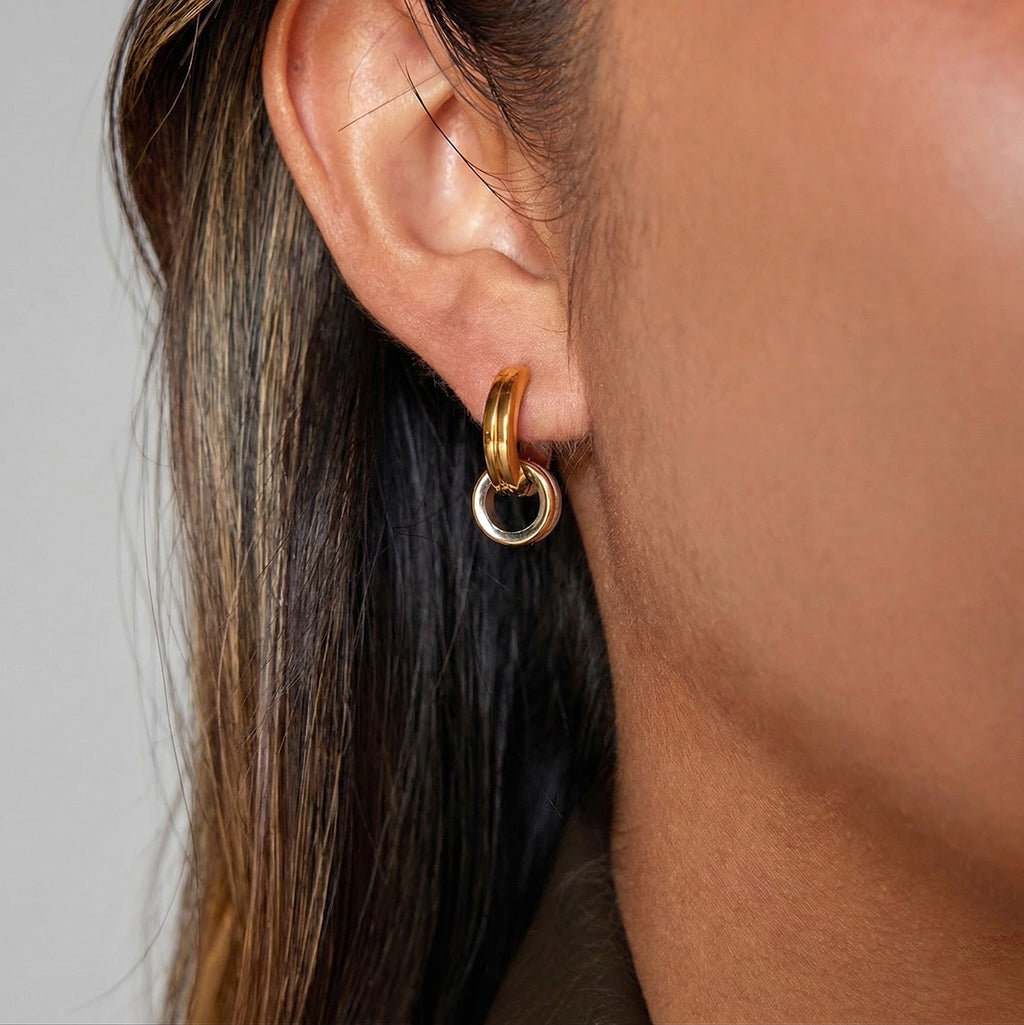 model wearing two-tone amethyst & sable axis cross over hoop earrings in 18k gold and stainless steel