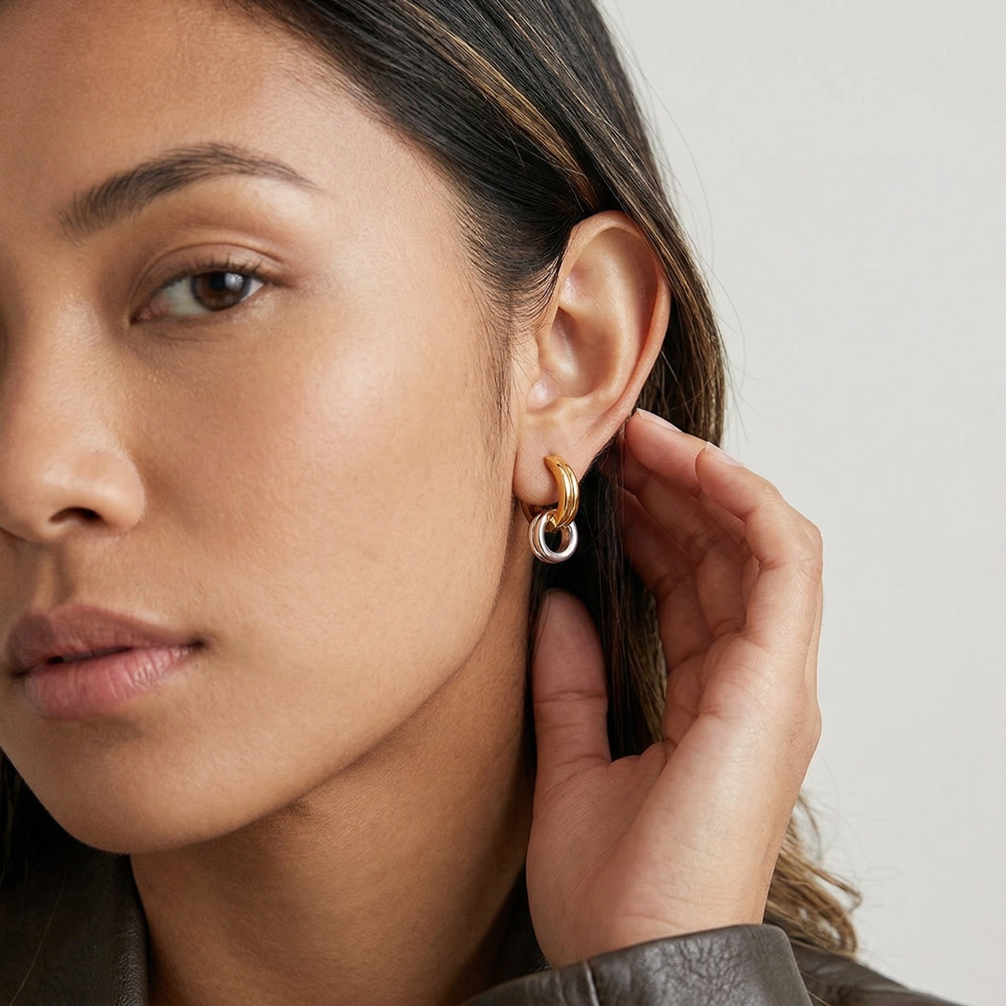 model wearing two-tone amethyst & sable axis cross over hoop earrings in 18k gold and stainless steel