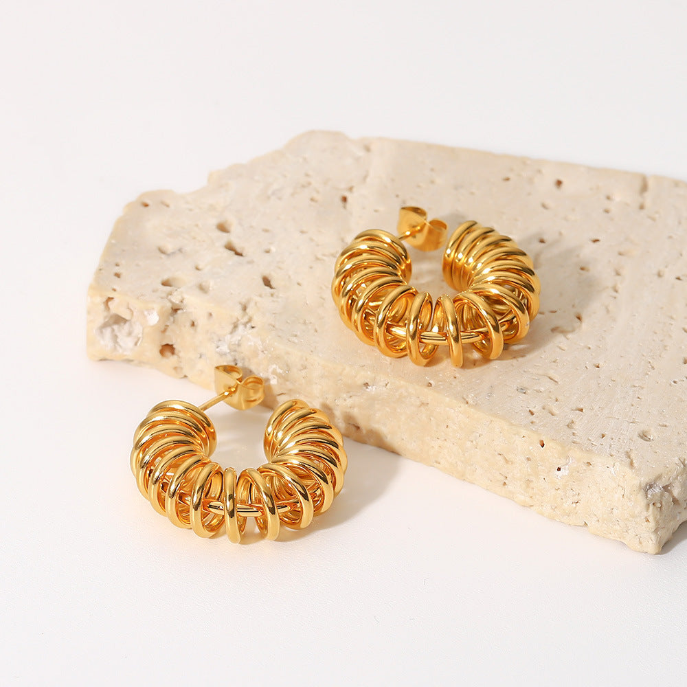 amethyst & sable axis current earrings in 18k gold on stone surface
