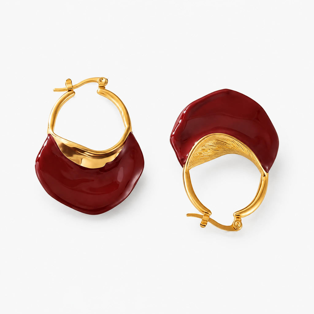 A pair of gold calypso camille hoop earrings with large, organic-shaped deep red enamel drops, shown on a clean white background.