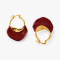 A pair of gold calypso camille hoop earrings with large, organic-shaped deep red enamel drops, shown on a clean white background.