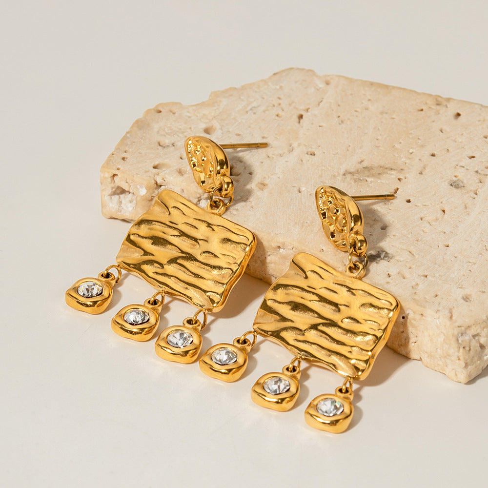 amethyst & sable calypso solara tassel earrings in 18k gold on stone surface