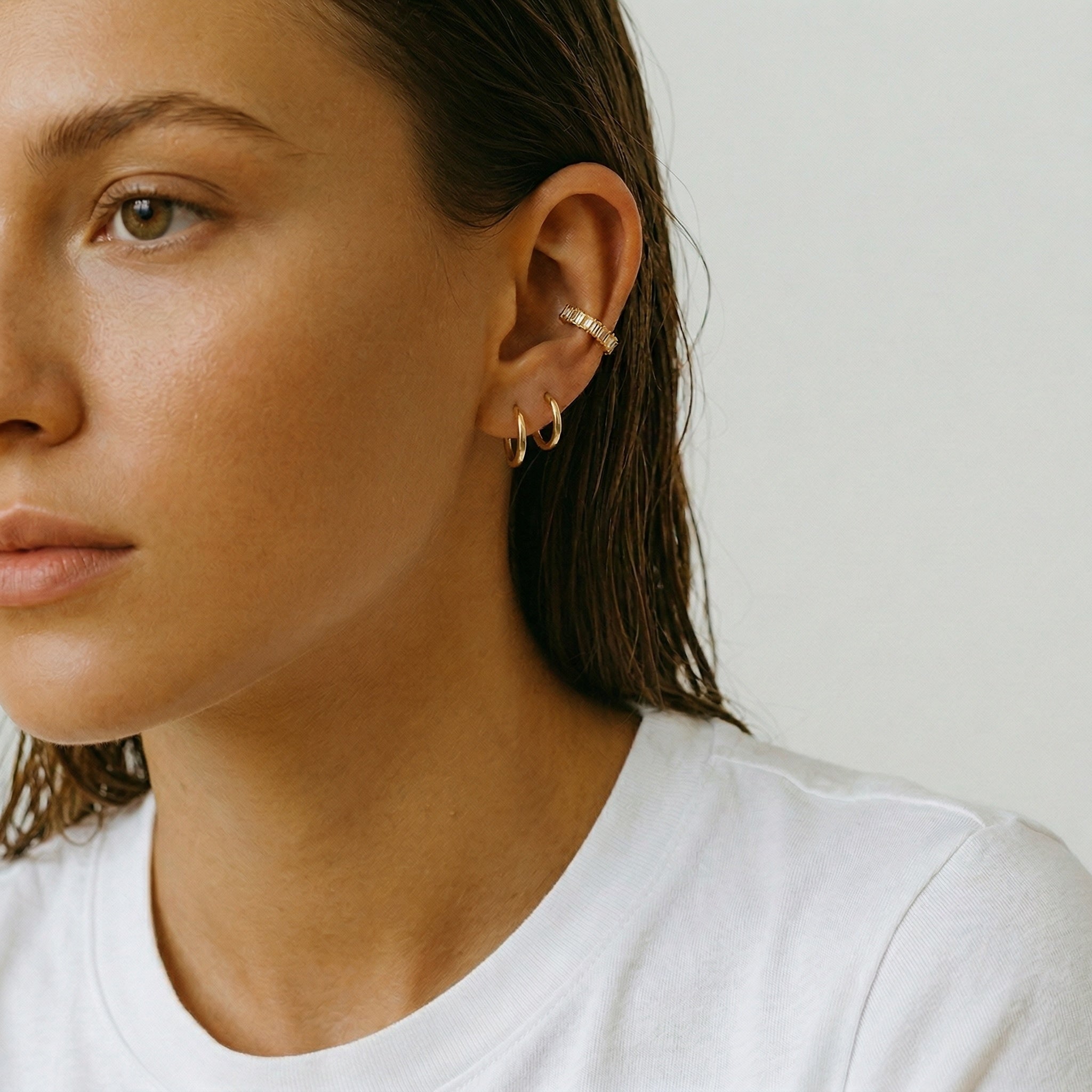 model wearing amethyst & sable luma ear cuffs in 18k gold with cubic zirconia crystal stones