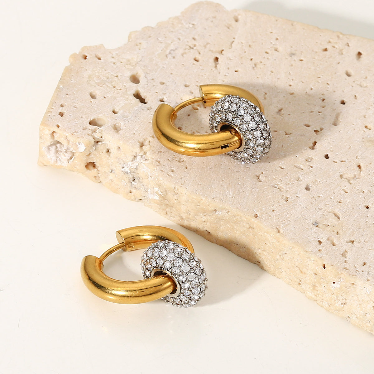 amethyst & sable luma halo drop earrings in 18k gold on stone surface