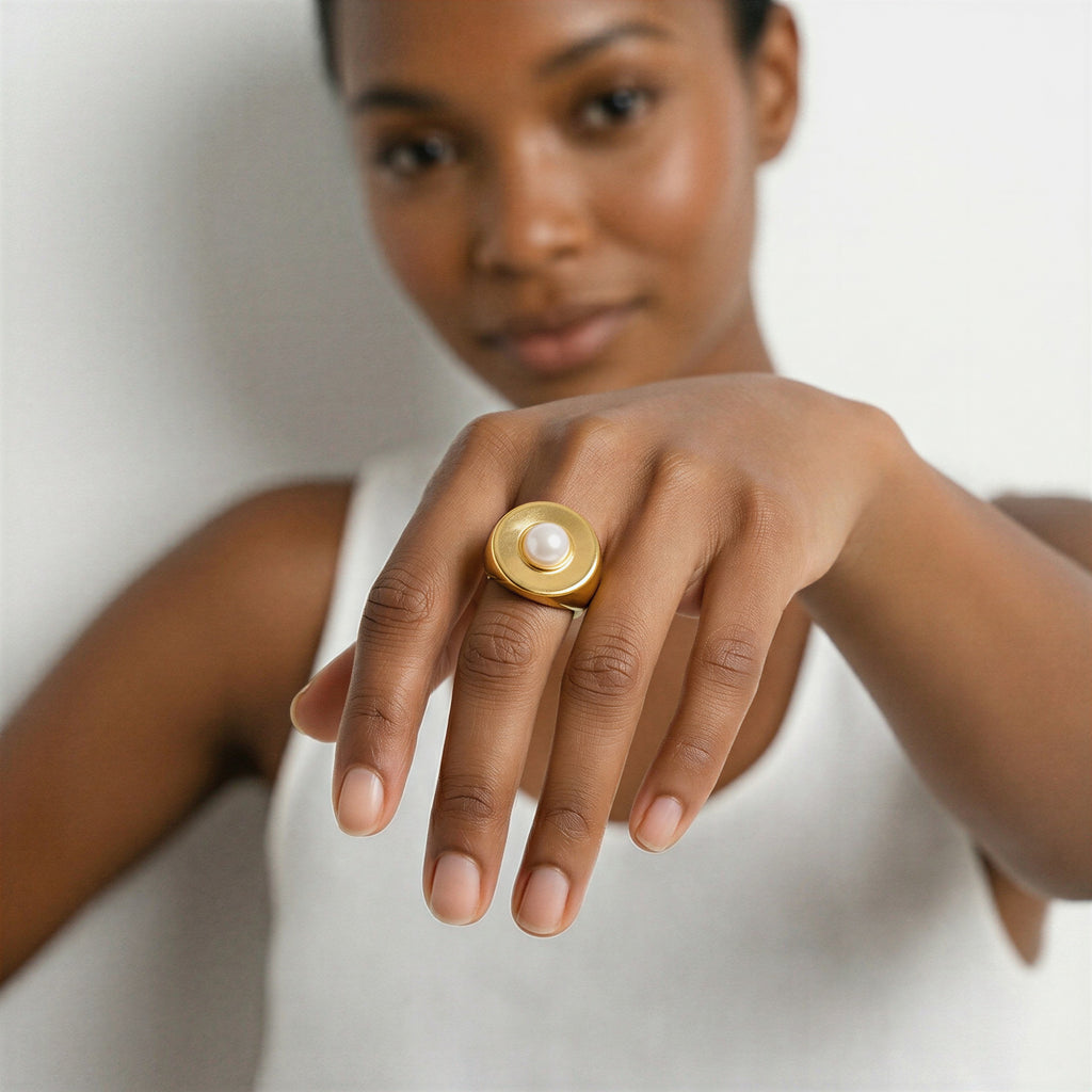 model wearing amethyst & sable selene halo pearl ring in 18k gold