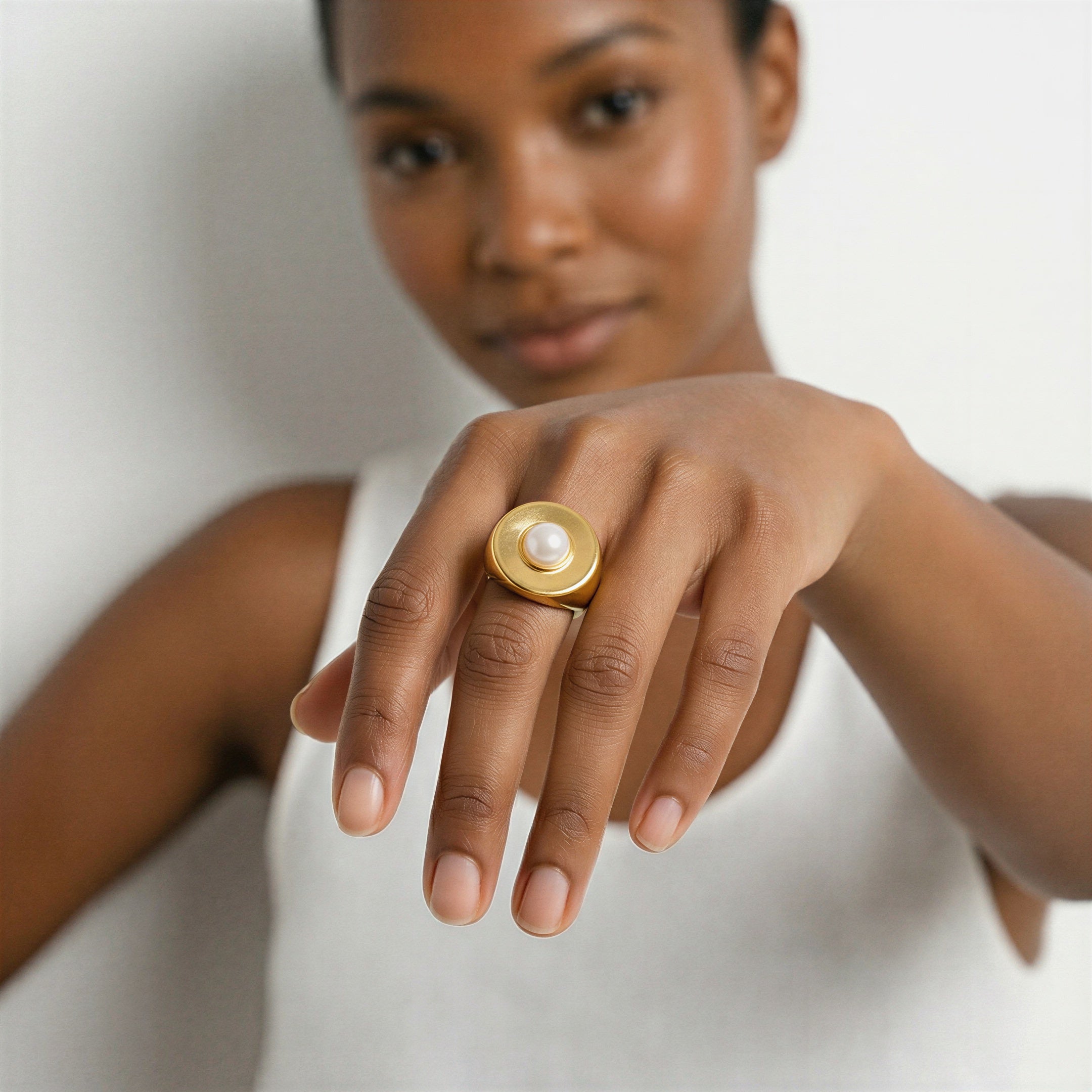 model wearing amethyst & sable selene halo pearl ring in 18k gold