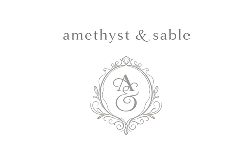 Logo for 'amethyst & sable' with a decorative 'A' and 'S' on a light gray background