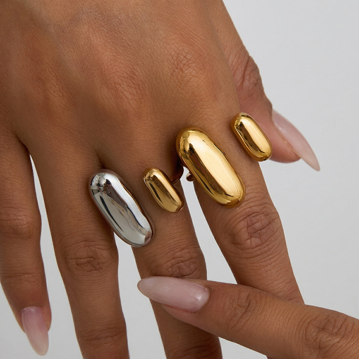 hand wearing Amethyst & Sabke axis form rings in mixed metal and gold