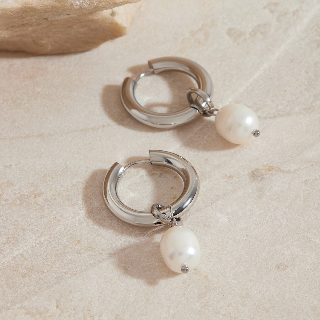 amethyst & sable Selene Pearl Drop Hoops in silver on stone surface