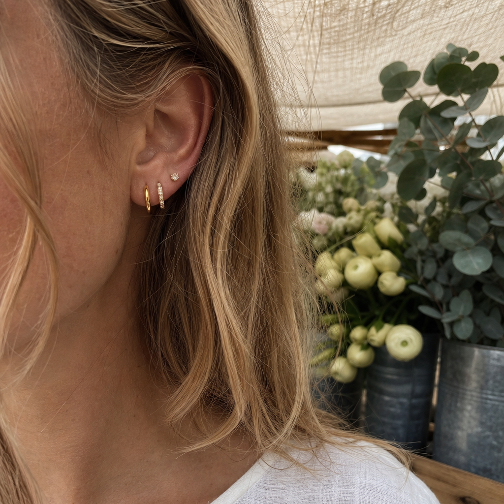 woman wearing amethyst & sable luma ear stack set in 18k gold in flower market