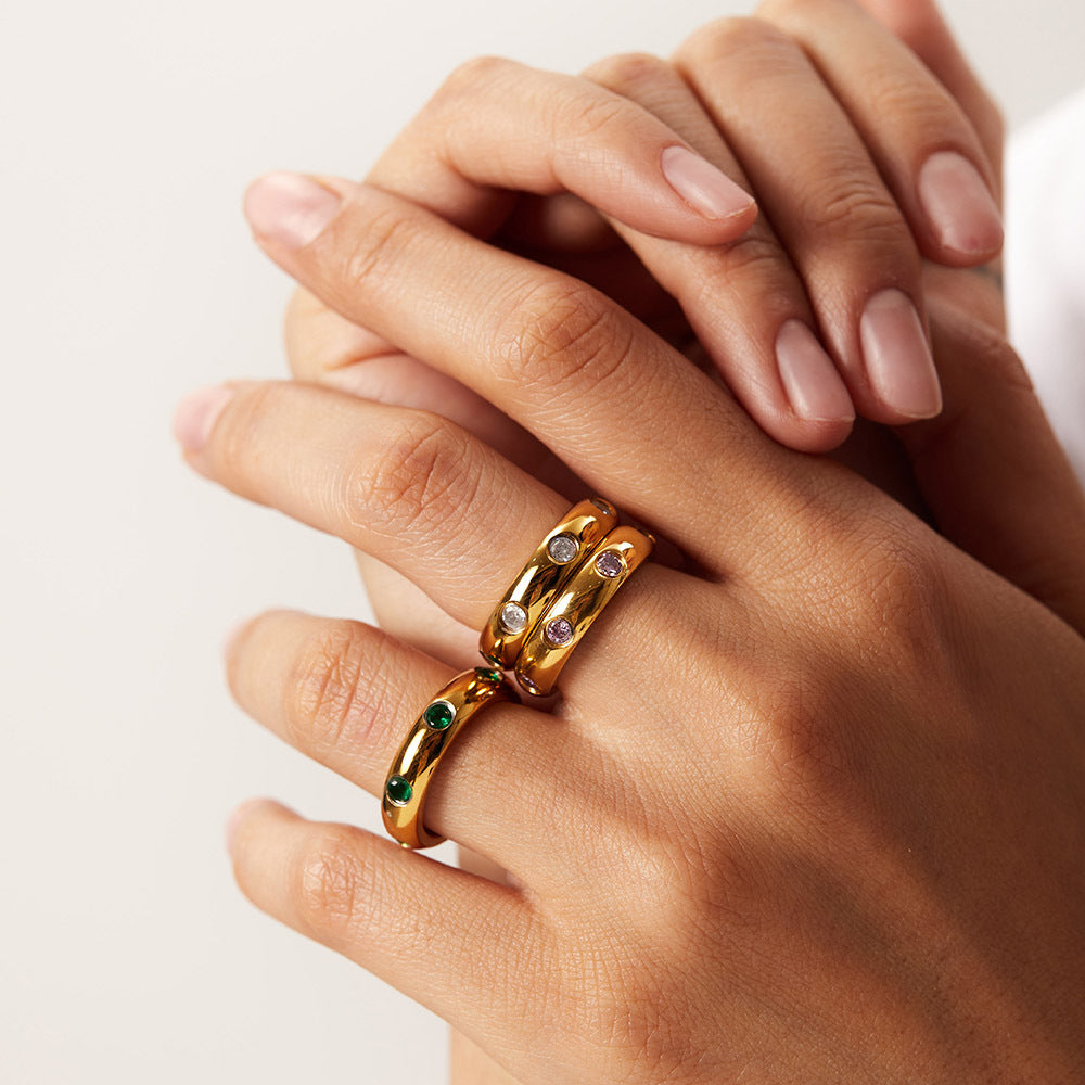 model wearing amethyst & sable soleil halo rings in 18k gold white and emerald